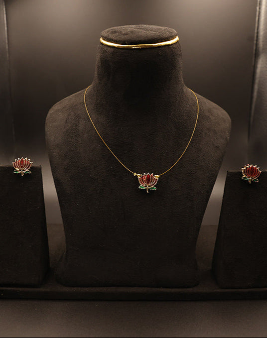 Jewelry set including necklace and earrings on a black stand against a dark background