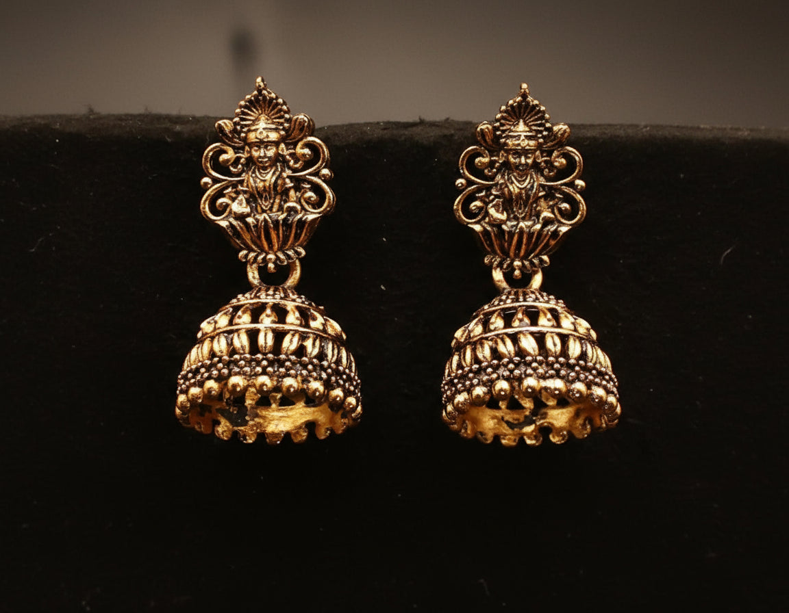 antique gold-toned jhumka earrings with an ornate temple jewelry design