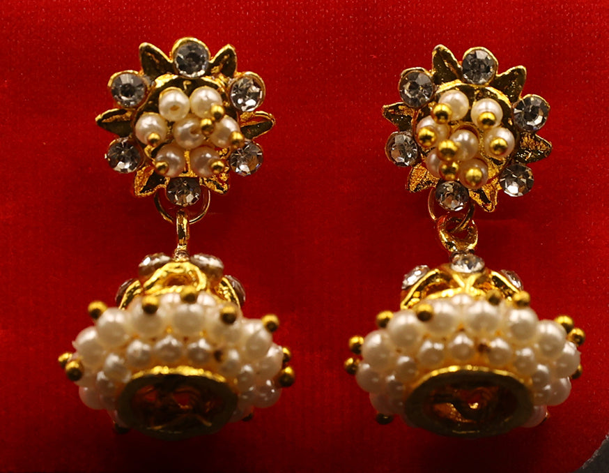 Gold and pearl earrings on a red background